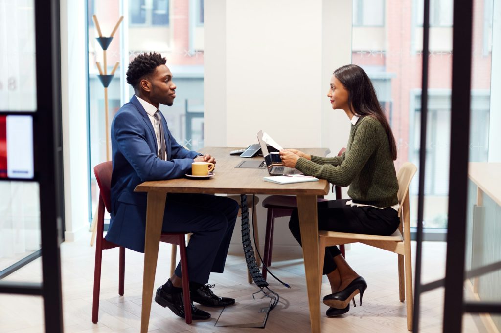 Businesswoman Interviewing Male Job Candidate In Meeting Room