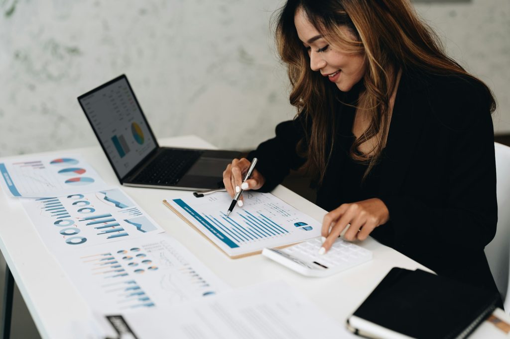 usiness analyzing investment charts with calculator laptop. Accounting and technology in office